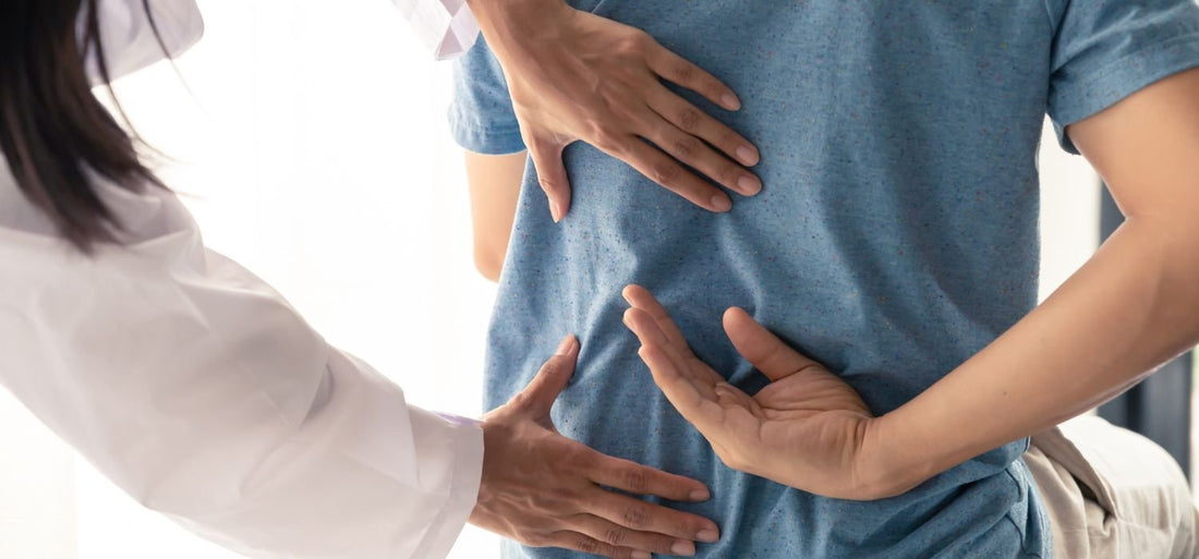 Professionnel de la santé posant ses mains sur le milieu du dos d'un patient.