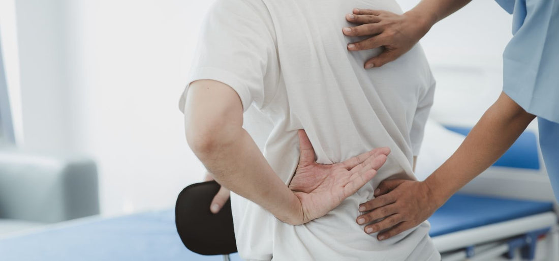 Homme avec le dos bloqué chez un kinésithérapeute